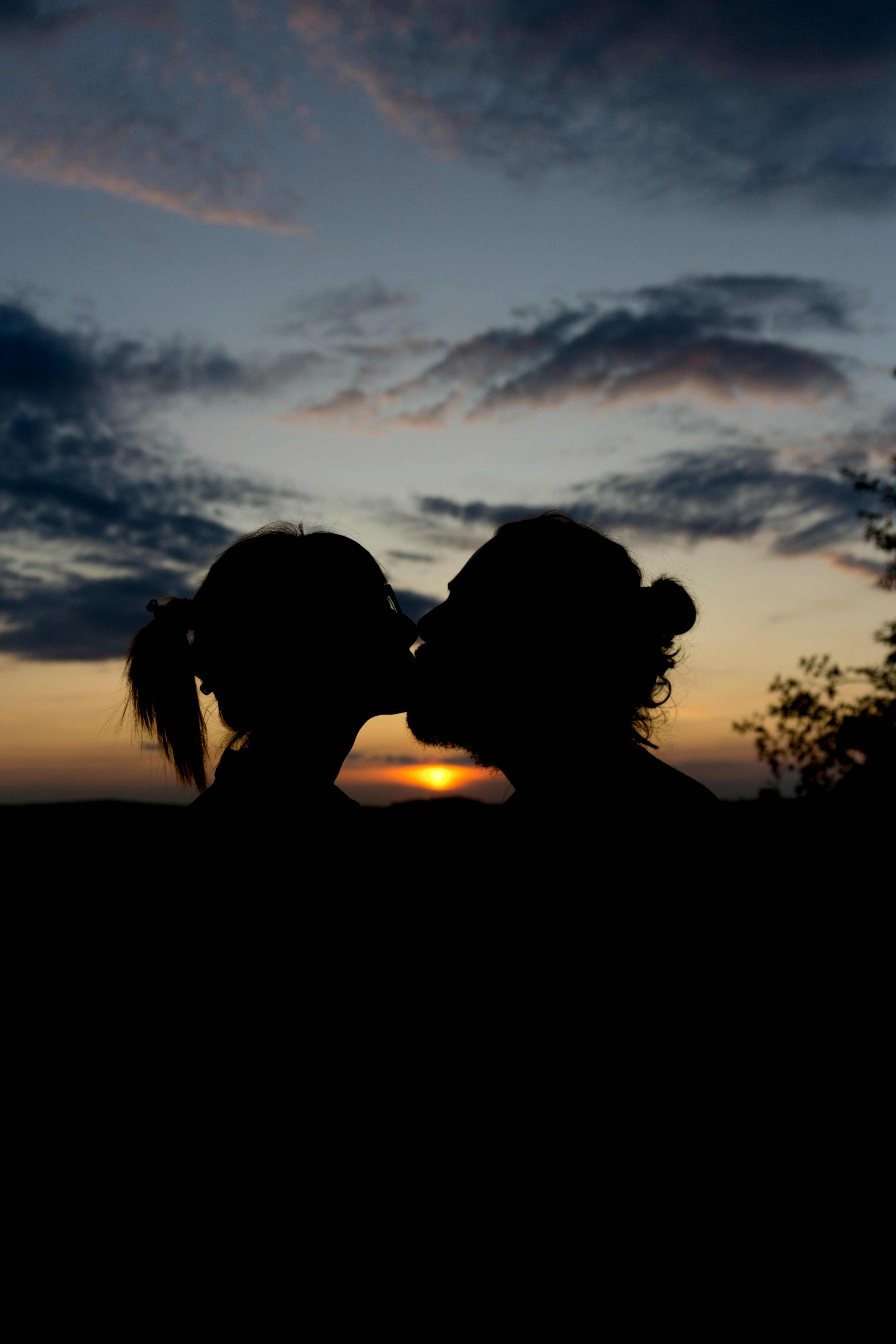 man and woman kissing during golden hour